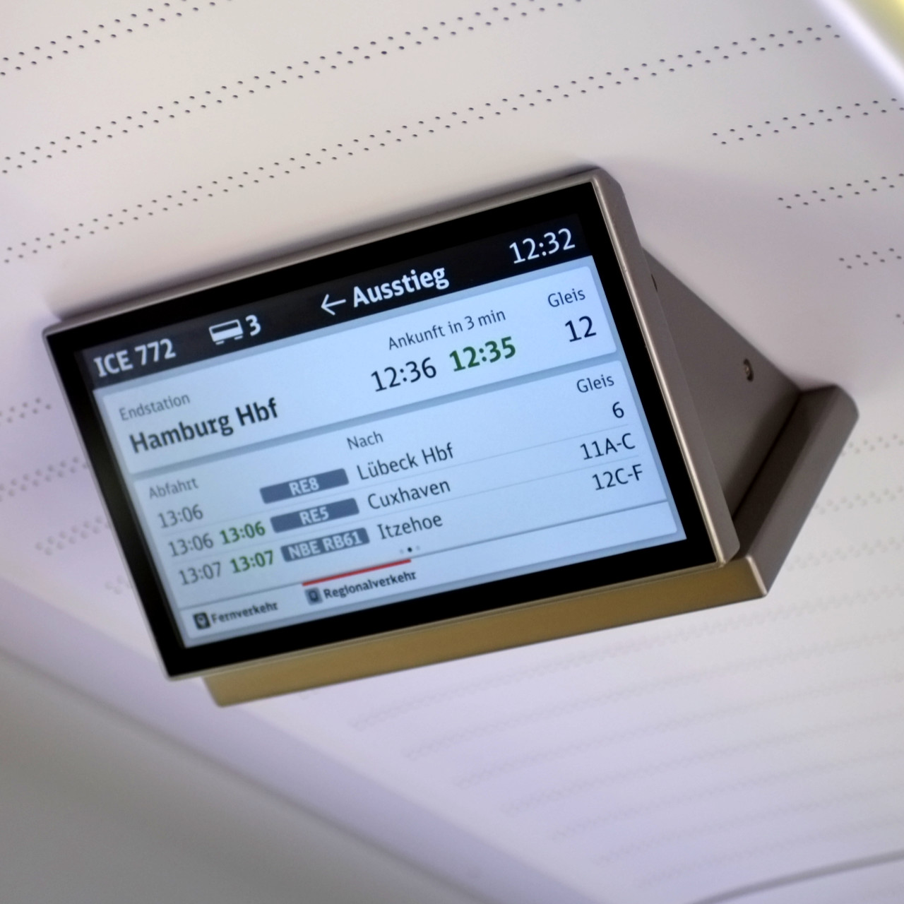 A photo of a train car timetable screen displaying town names Cuxhaven and Itzehoe.
