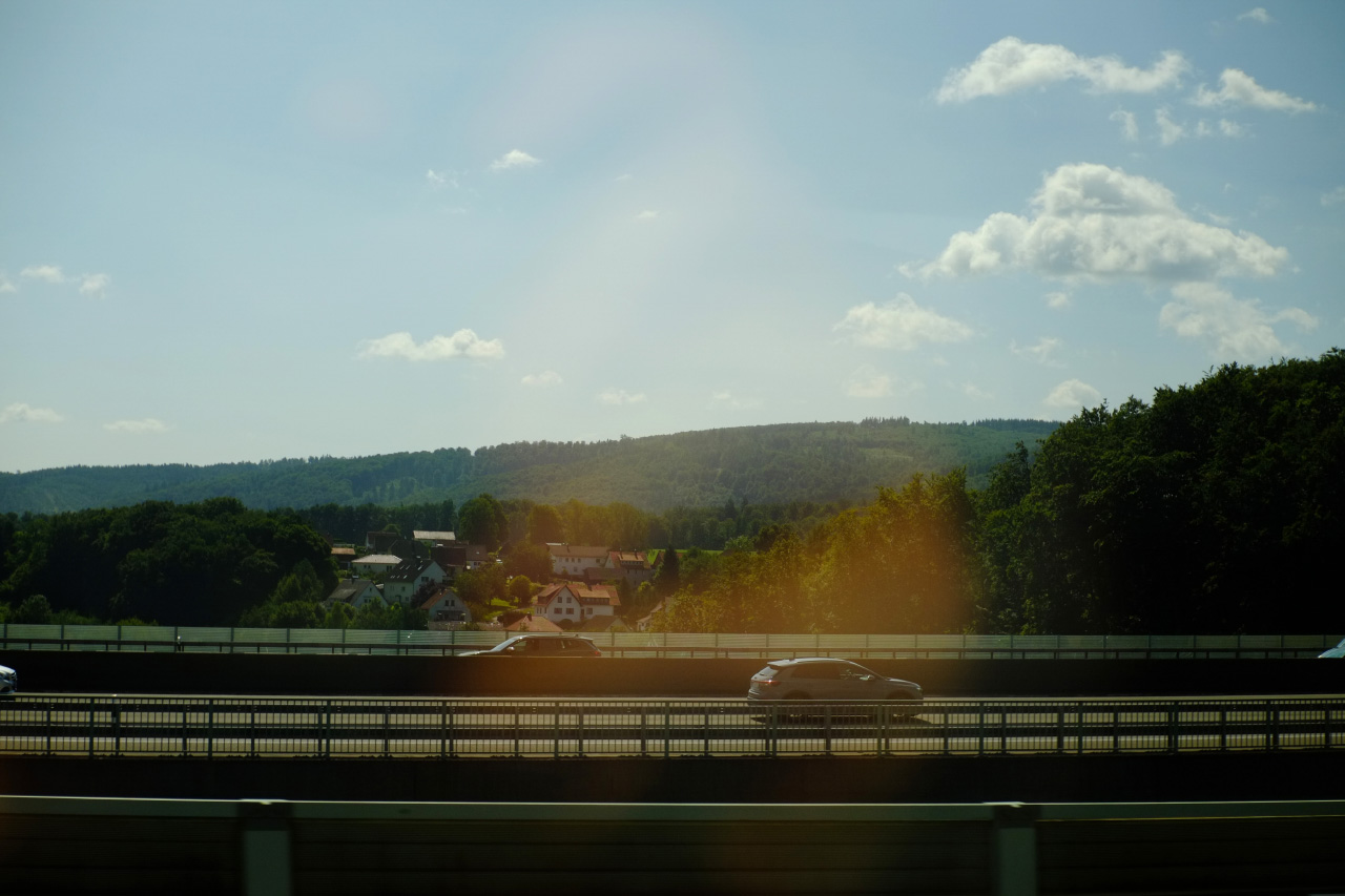 A photo of an automobile mountain bridge shot through a train window.